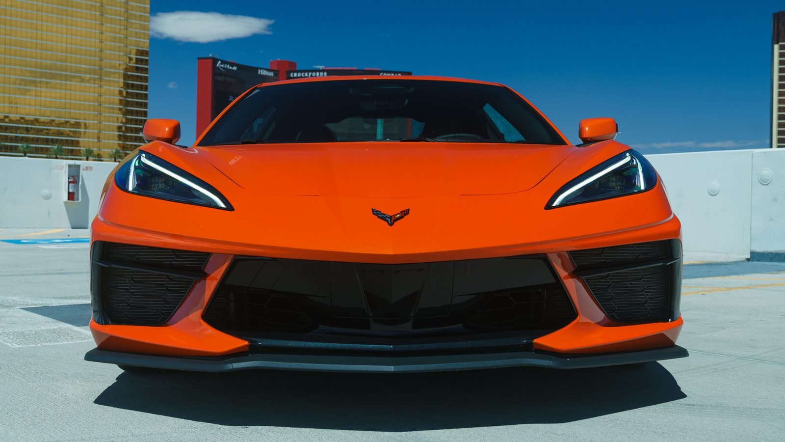 Orange Chevrolet Corvette C8 Stingray rental parked with the Las Vegas Strip in the background